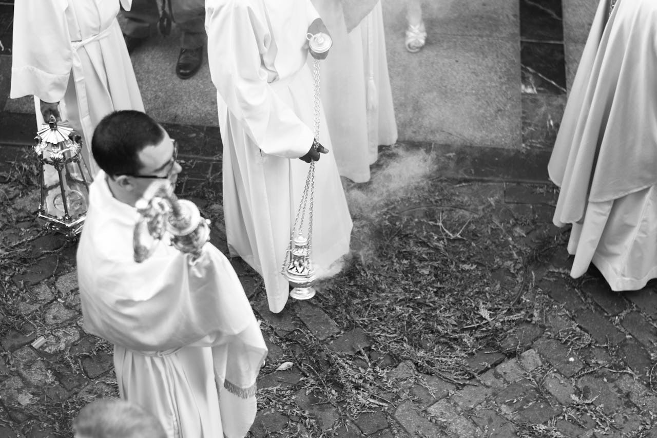 Priest during a Catholic procession in black and white, featured in Catholic news blog Apostle Times.